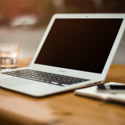 A white MacBook on a wooden table