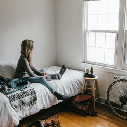 A person working remotely from their bedroom