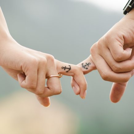 A couple holding hands during a stressful period of their lives