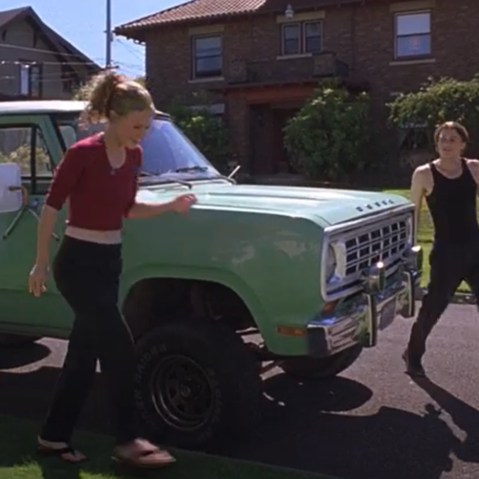 Kat and Patrick from Ten Things I Had About You standing by a green car