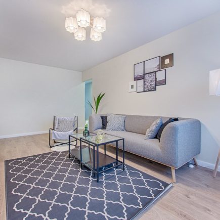 A living room with sofa, table, and rug in neutral colours to make a haven of calm.