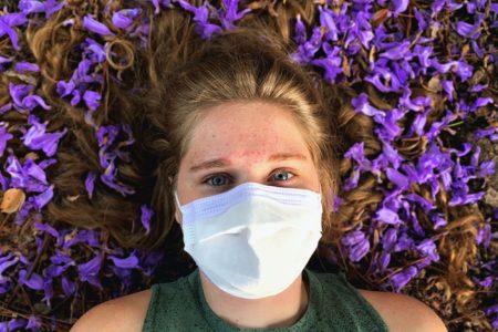 Person in mask struggling with COVID anxiety