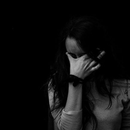 A woman pushes her thumb and forefinger into her eyebrows as she struggles to find the motivation to work